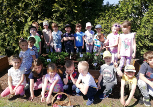 dzieci prezentują swoją pracę w swoim ogródku z ziołami